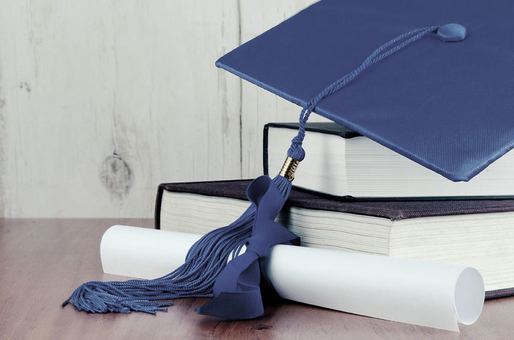 Blue graduation hat on top of books