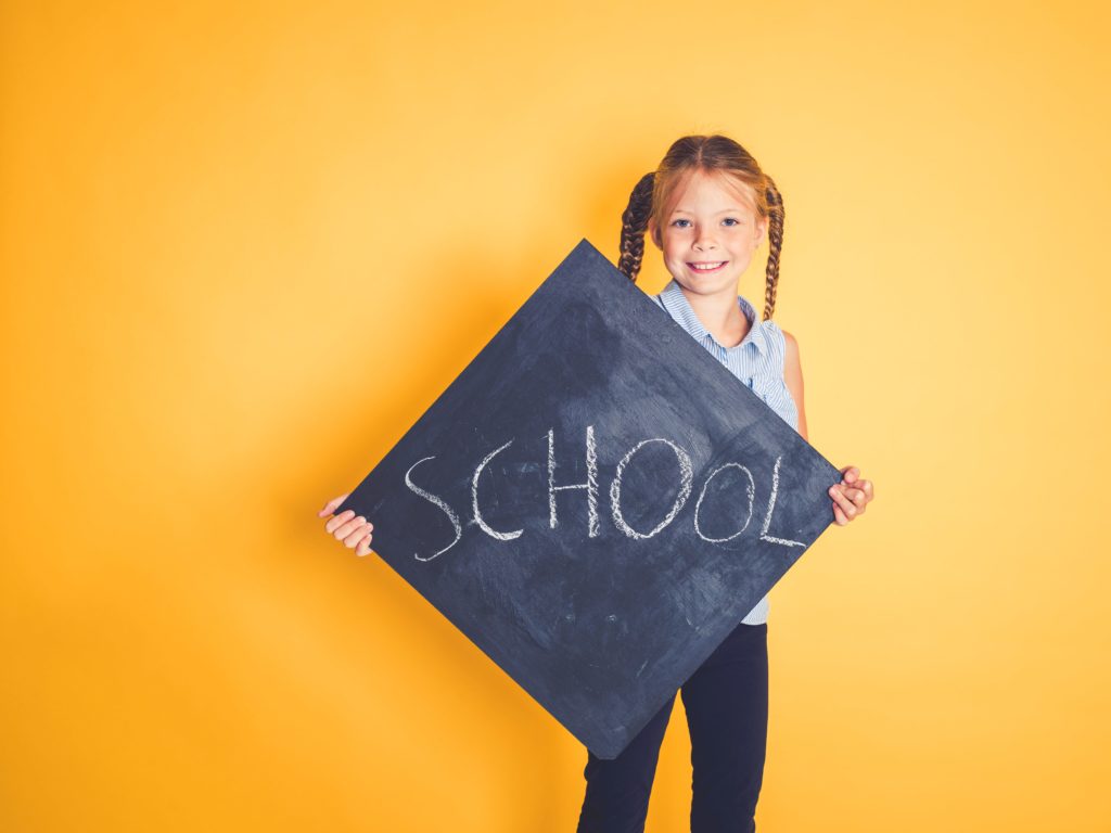 Little girl holding up back to school sign