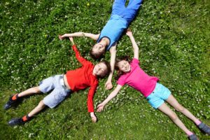 Children lying in grass during summer break