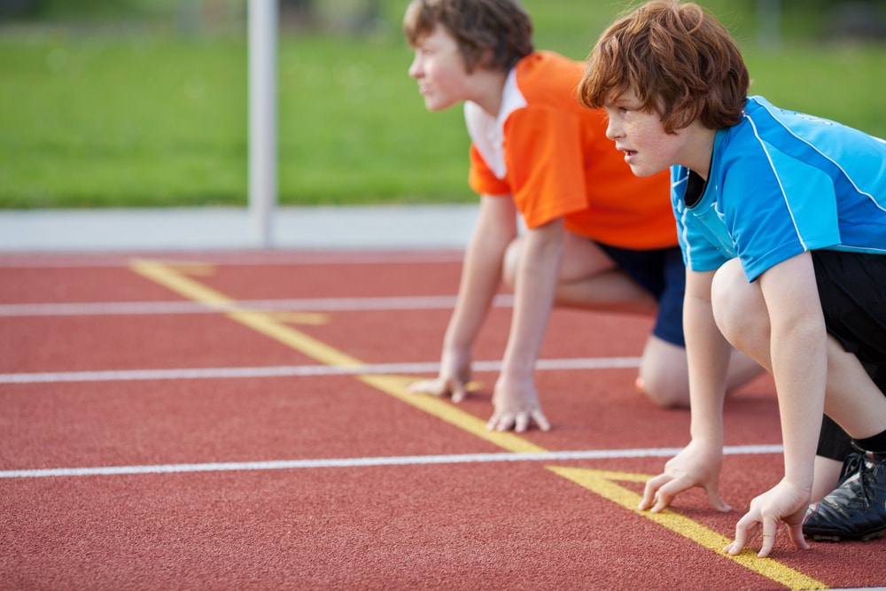 Two young men in starting position at racetrack