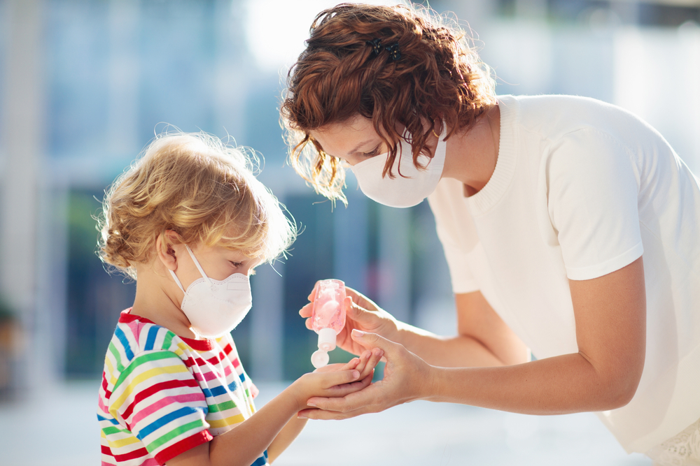 Mom squirting hand sanitizer onto son’s hands