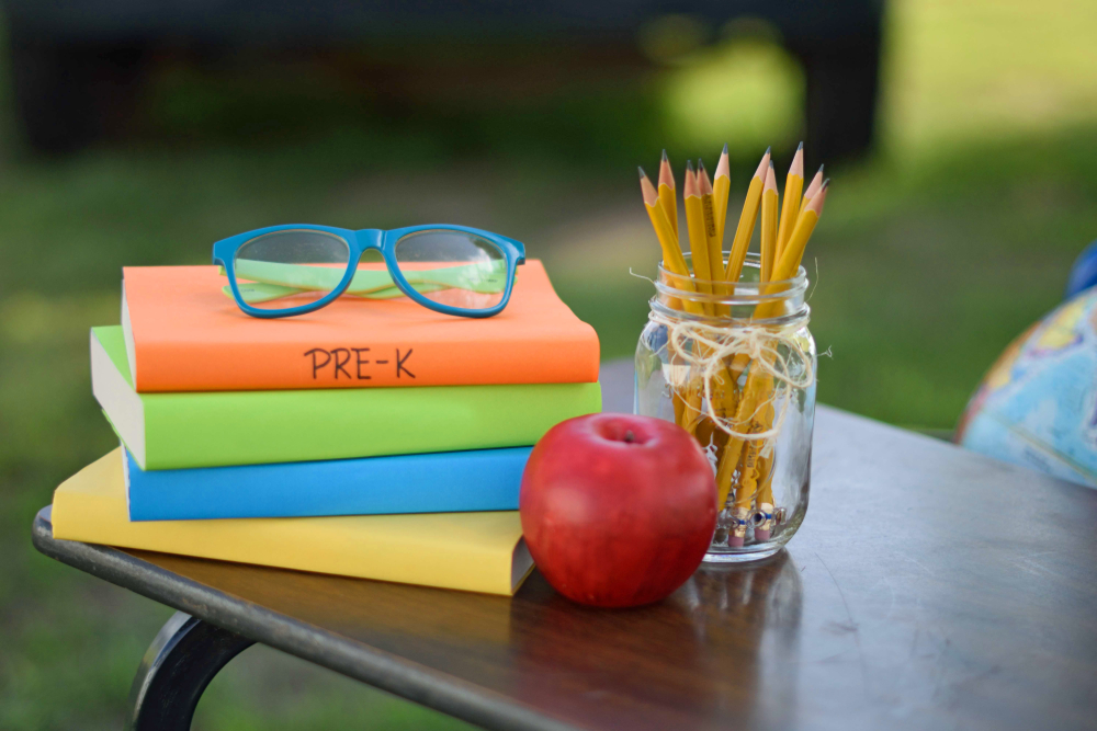 Books, pencils, and an apple on a desk