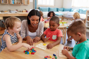 Preschoolers and teacher playing with colored shapes