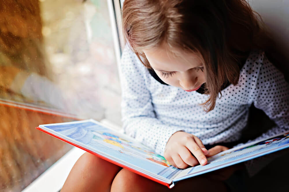 female toddler reading a book