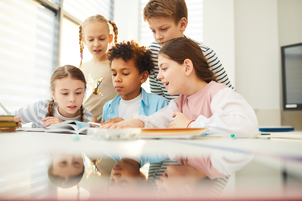 Group of middle school students looking at a book