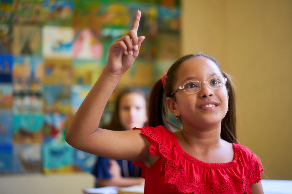 Child raising hand in class