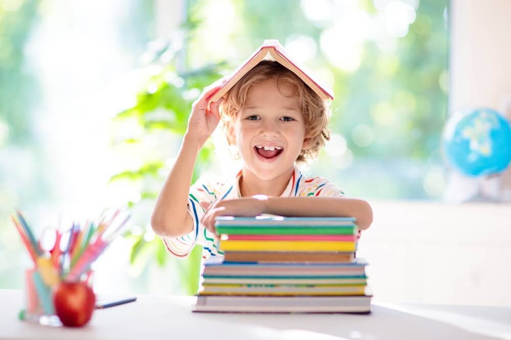 Preschool boy with a stack of books